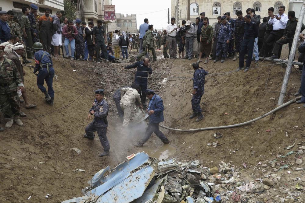 在也门首都萨那,也门军人和警察在战斗机坠毁现场调查.