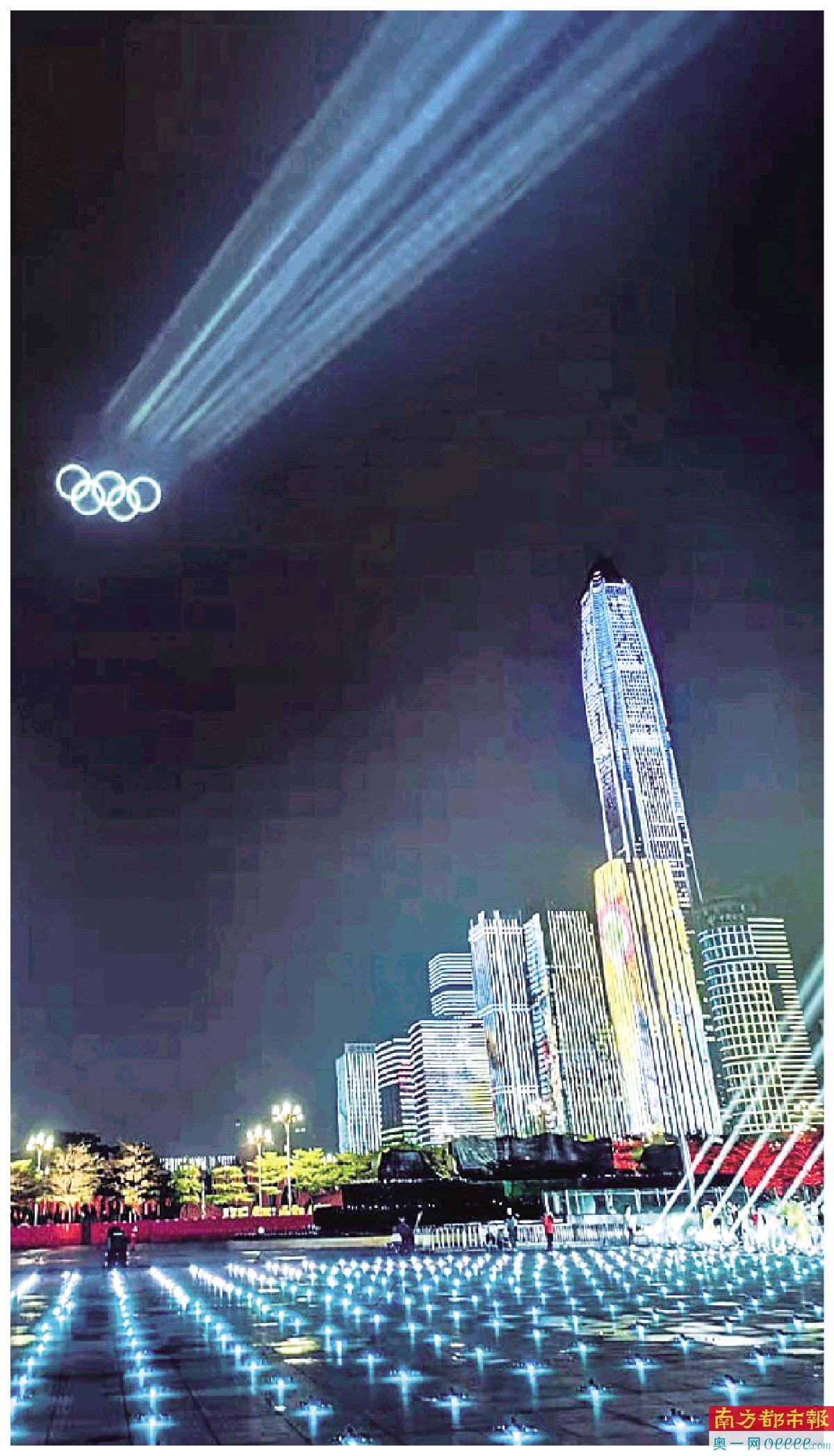 激光光柱冲上云霄,在云上写出“天下一家”,并在云端展示“五环”标志。